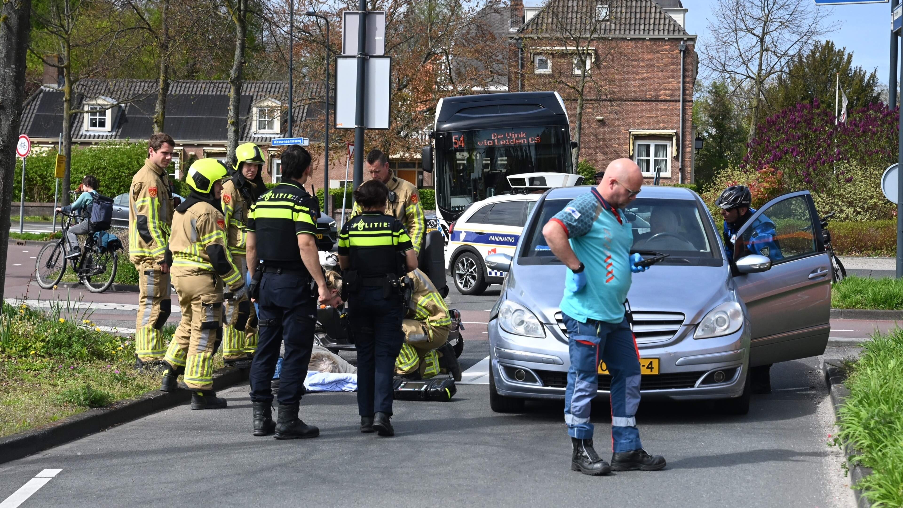 Vrouw in scootmobiel aangereden door auto in Leiden, hulpdiensten in de buurt vanwege gaslekkage. Vrouw in scootmobiel aangereden door auto in Leiden, hulpdiensten in de buurt vanwege gaslekkage.