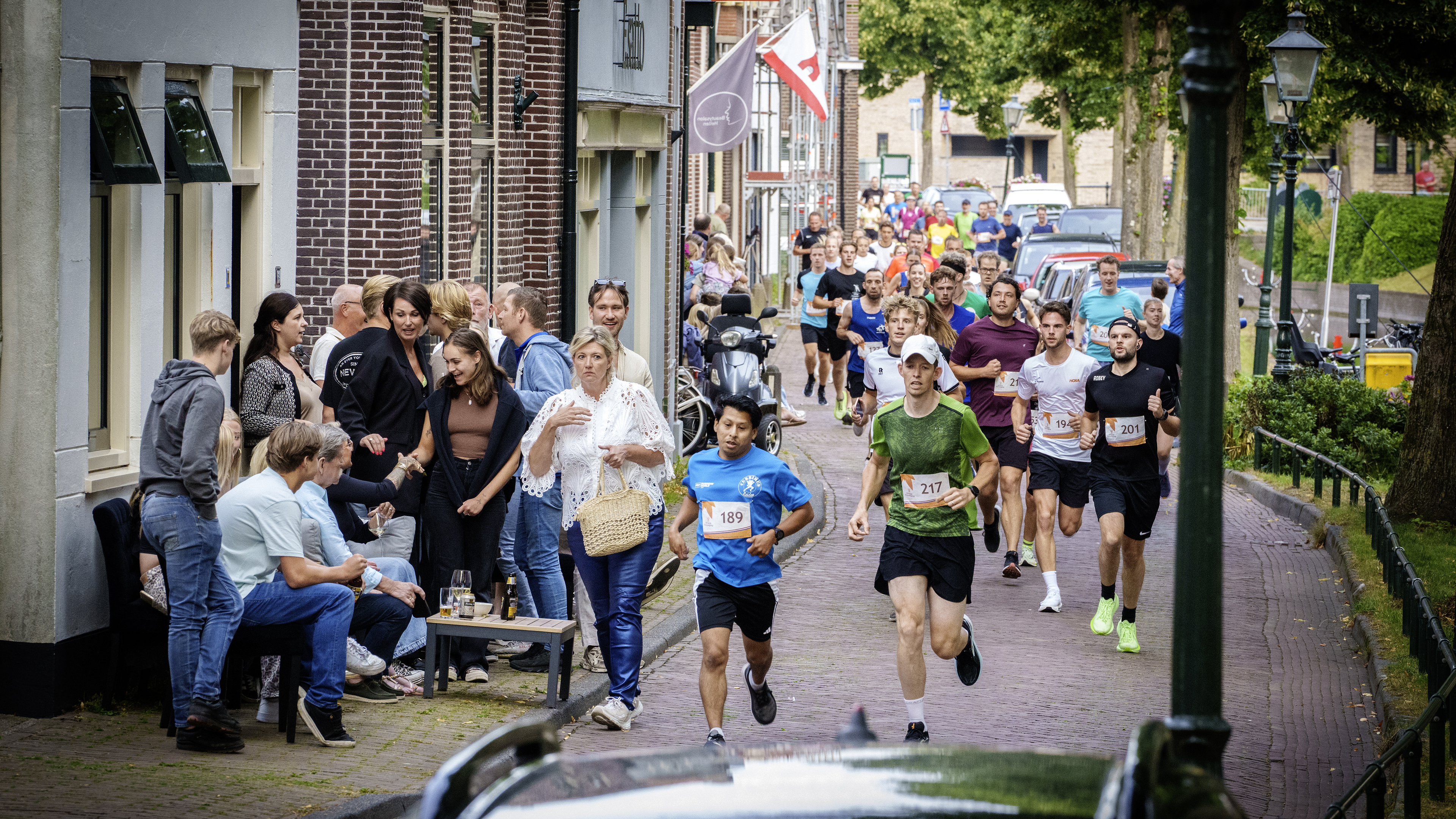 Terwijl de hardlopers afzien, genieten de Rijnsburgers van hun biertje tijdens de Vlietloop